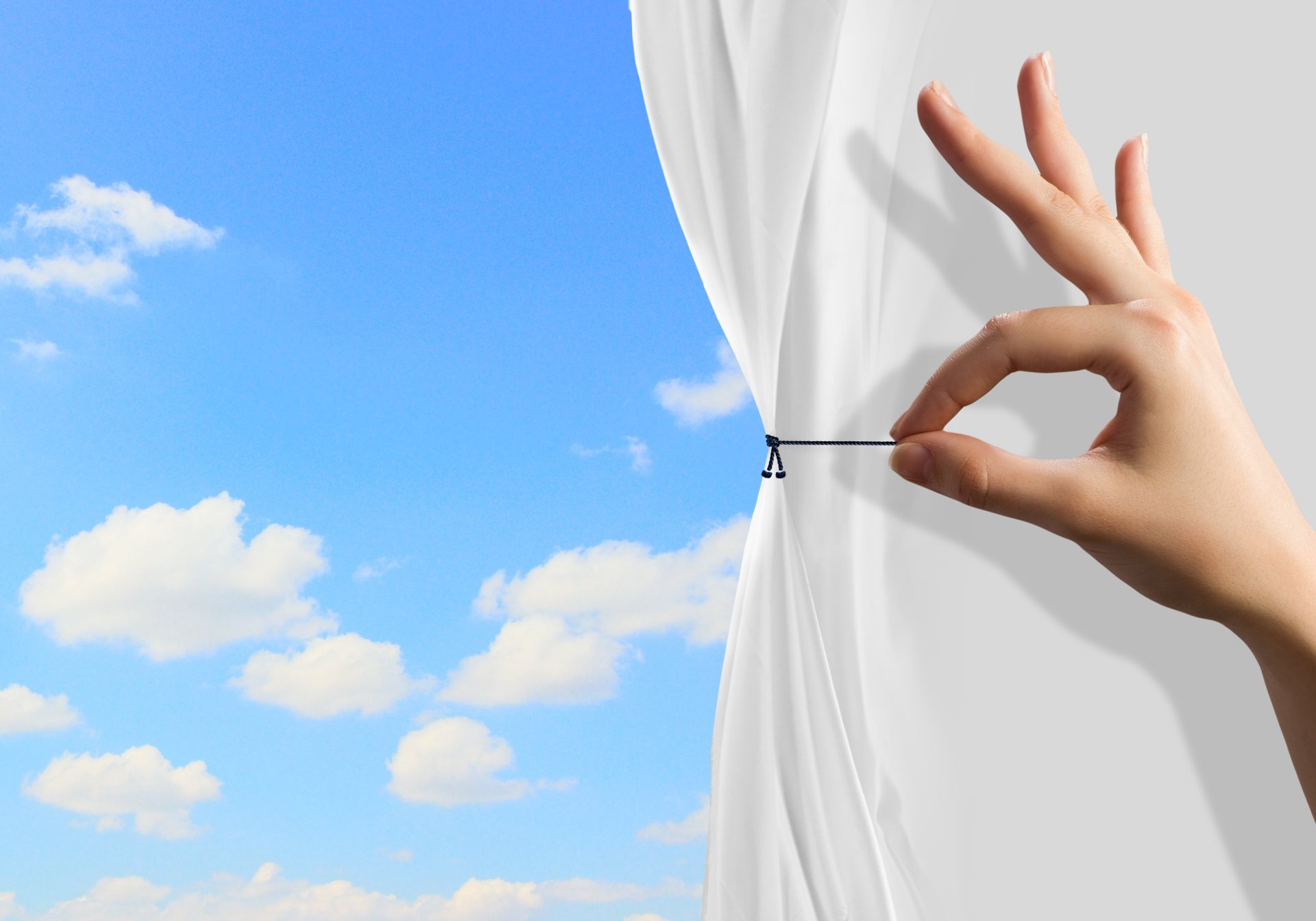 ruka koja pomera pozorisnu zavesu i oblaci