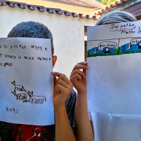 Deca drže crteže u rukama