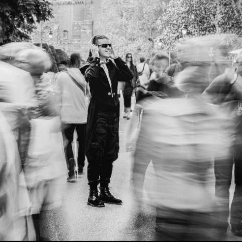 Čovek u gužvi drži slušalice